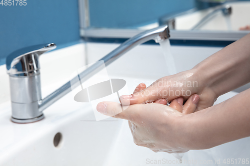 Image of Woman washing hands carefully in bathroom close up. Prevention of infection and pneumonia virus spreading