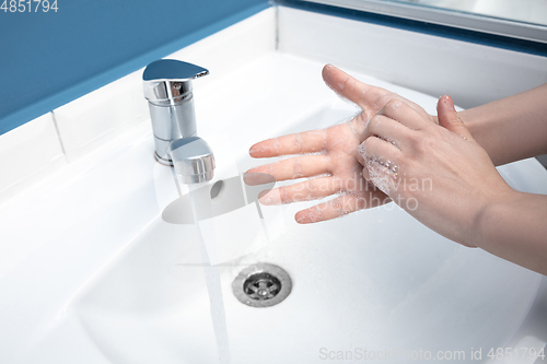 Image of Woman washing hands carefully in bathroom close up. Prevention of infection and pneumonia virus spreading