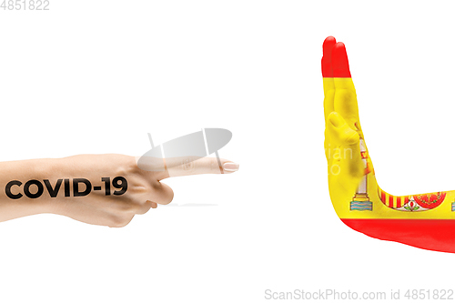 Image of Stop the epidemic. Human hands colored in flag of Spain and coronavirus - concept of spreading of virus