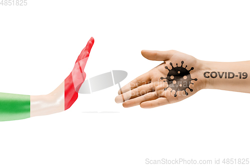 Image of Stop shaking hands. Human hands colored in flag of Italy and coronavirus - concept of spreading of virus