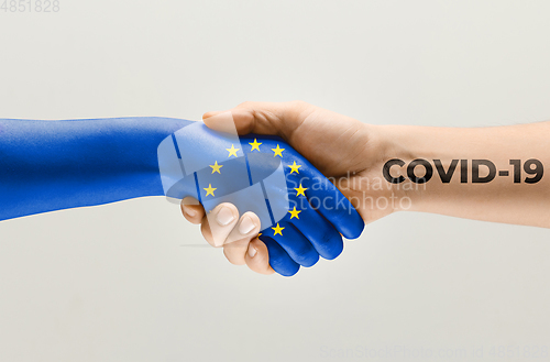 Image of Human hands colored in flag of Europian Union and coronavirus - concept of spreading of virus