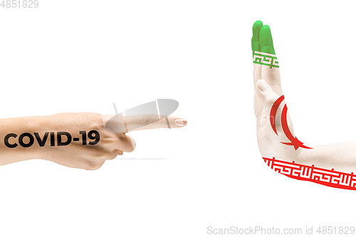 Image of Stop the epidemic. Human hands colored in flag of Iran and coronavirus - concept of spreading of virus