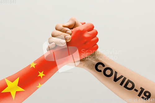 Image of Human hands colored in flag of China and coronavirus - concept of spreading of virus, fighting