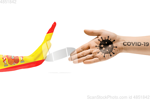 Image of Stop shaking hands. Human hands colored in flag of Spain and coronavirus - concept of spreading of virus