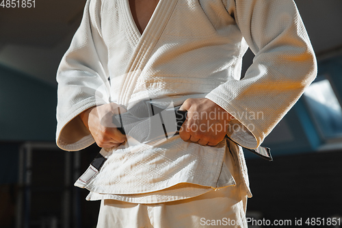 Image of Young judo fighter in kimono posing comfident in the gym, strong and healthy