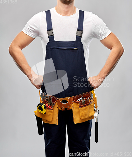 Image of worker or builder in overall with working tools