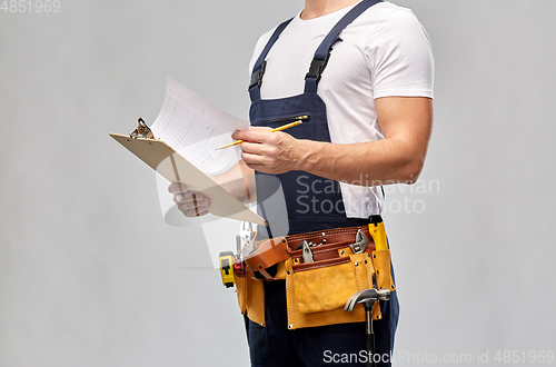 Image of builder with clipboard, pencil and working tools