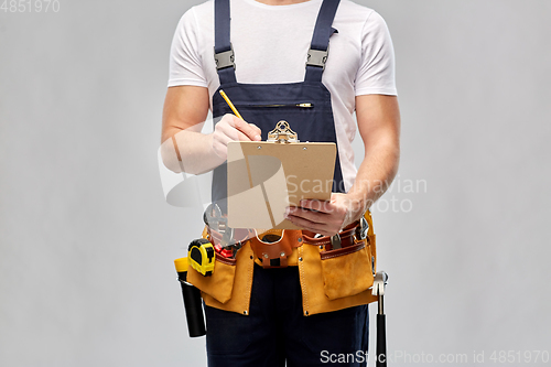 Image of builder with clipboard, pencil and working tools