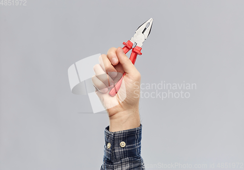 Image of close up of builder's hand holding pliers
