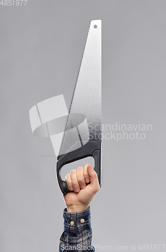 Image of close up of builder's hand holding saw