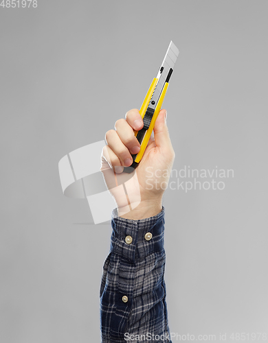 Image of close up of builder's hand holding knife