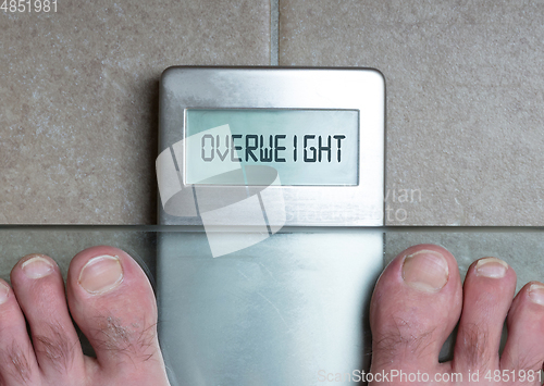 Image of Man\'s feet on weight scale - Overweight