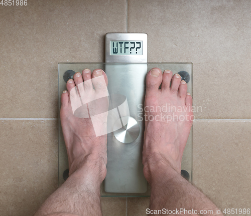 Image of Man\'s feet on weight scale - WTF!!!