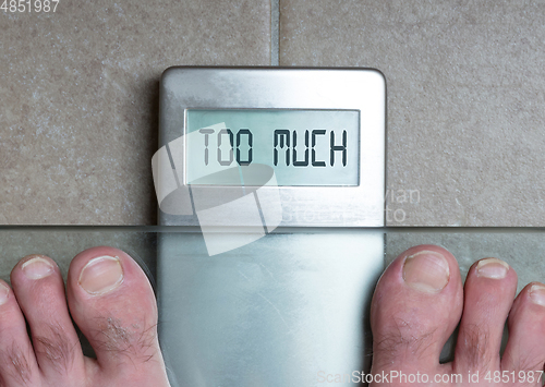 Image of Man\'s feet on weight scale - Too much