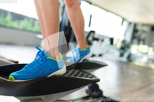 Image of Woman step on Elliptical machine 