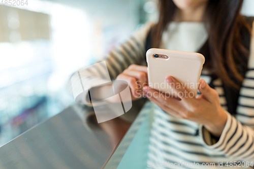 Image of Woman use of mobile phone in shopping mall