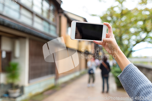 Image of Woman taking photo with cellphone in kanazawa