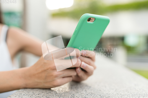 Image of Woman using mobile phone in the street