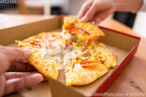 Image of Woman taking one slice of pizza