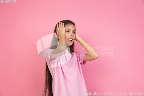 Image of Caucasian little girl portrait isolated on pink studio background, emotions concept