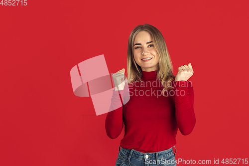 Image of Monochrome portrait of young caucasian blonde woman on red background