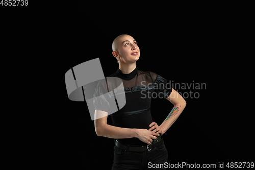 Image of Monochrome portrait of young caucasian bald woman on black background