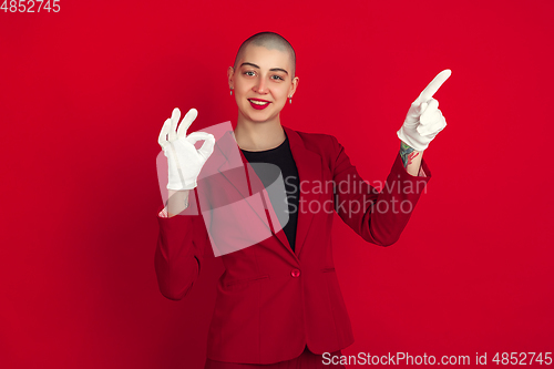Image of Portrait of young caucasian bald woman on red background