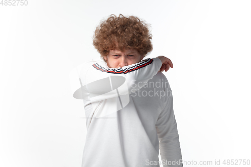 Image of How coronavirus changed our lives. Young man sneezing on white background