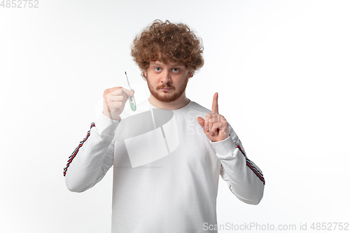 Image of How coronavirus changed our lives. Young man checking, taking temperature on white background