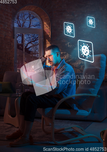 Image of Shocked, upset and sad man using gadgets to get information of coronavirus pandemic spread