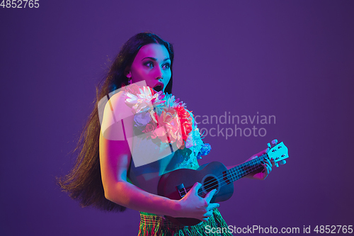 Image of Fabulous Cinco de Mayo female dancer on purple studio background in neon light