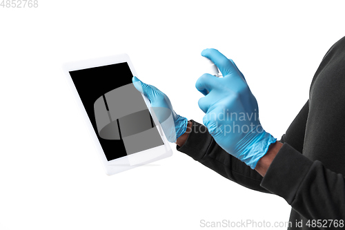 Image of How coronavirus changed our lives. Young man disinfecting gadgets surfaces on white background