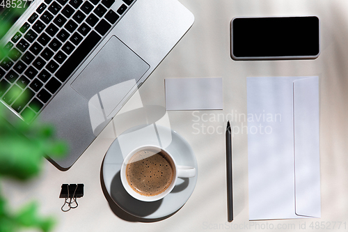 Image of Creative and cozy workplace at home office, inspirational mock up with plant shadows on table surface