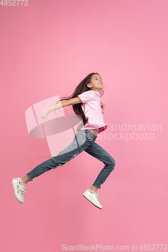 Image of Caucasian little girl portrait isolated on pink studio background, emotions concept