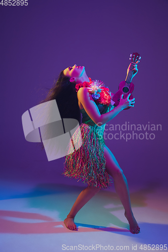 Image of Fabulous Cinco de Mayo female dancer on purple studio background in neon light