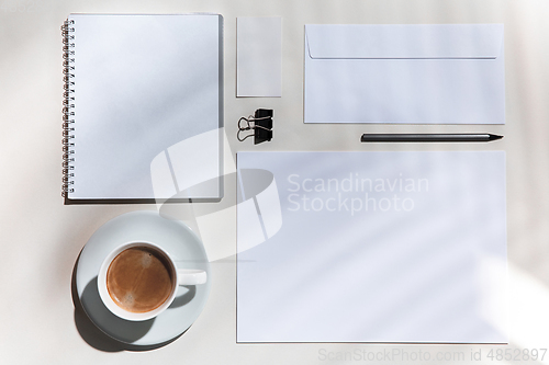 Image of Creative and cozy workplace at home office, inspirational mock up with plant shadows on table surface