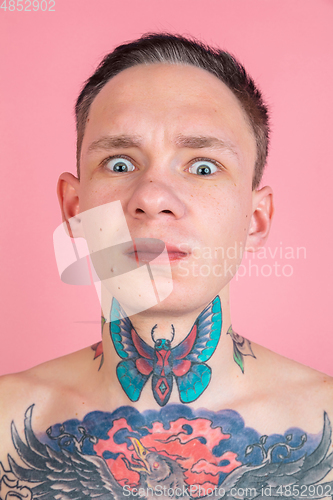 Image of Portrait of young man with freaky appearance on pink background