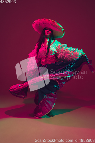 Image of Fabulous Cinco de Mayo female dancer on purple studio background in neon light