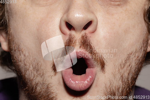 Image of Close-up male mouth illustrating emotions. Cosmetology, dentistry and beauty care, facial expression