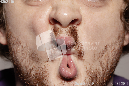 Image of Close-up male mouth illustrating emotions. Cosmetology, dentistry and beauty care, facial expression
