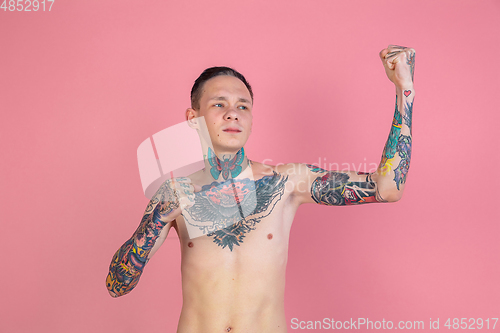 Image of Portrait of young man with freaky appearance on pink background