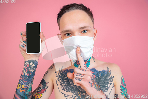 Image of Portrait of young man with freaky appearance on pink background