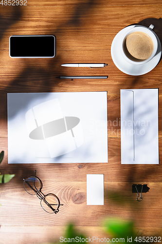 Image of Creative and cozy workplace at home office, inspirational mock up with plant shadows on table surface