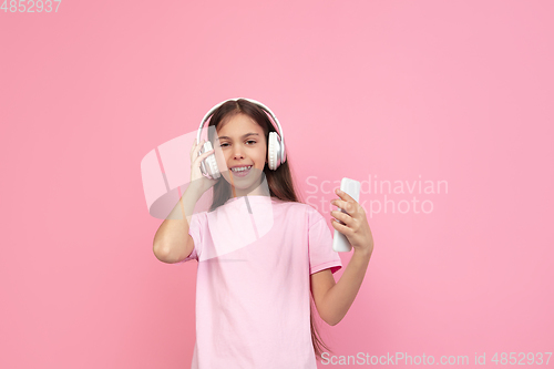 Image of Caucasian little girl portrait isolated on pink studio background, emotions concept