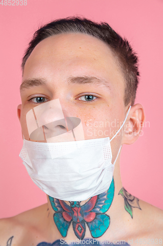 Image of Portrait of young man with freaky appearance on pink background