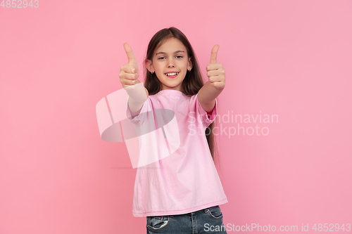 Image of Caucasian little girl portrait isolated on pink studio background, emotions concept