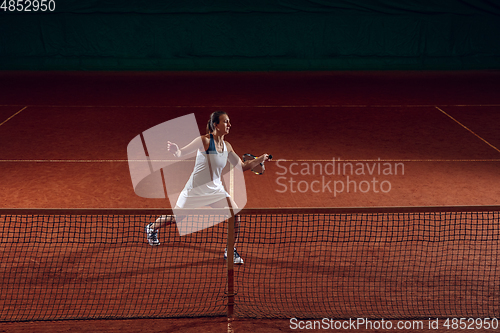 Image of Young caucasian professional sportswoman playing tennis on sport court background