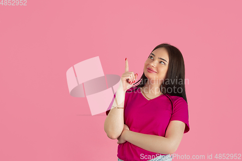 Image of Monochrome portrait of young caucasian brunette woman on pink background