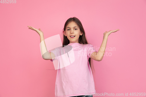 Image of Caucasian little girl portrait isolated on pink studio background, emotions concept