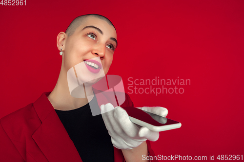 Image of Portrait of young caucasian bald woman on red background